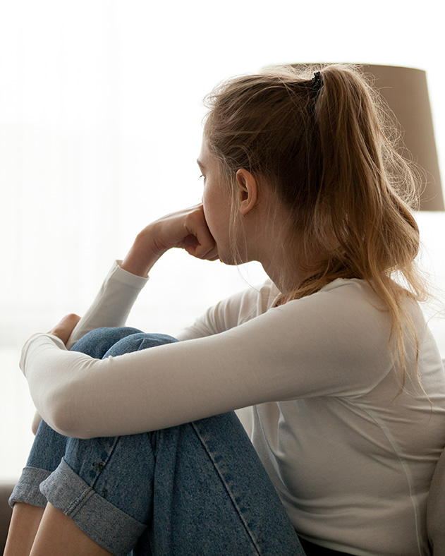 anxiety_therapy_coopersburg_pa_michael_brown Young woman looking out the window experiencing anxiety