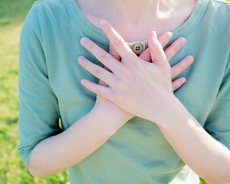 EMDR_therapy Woman with hands on her heart working on EMDR in therapy
